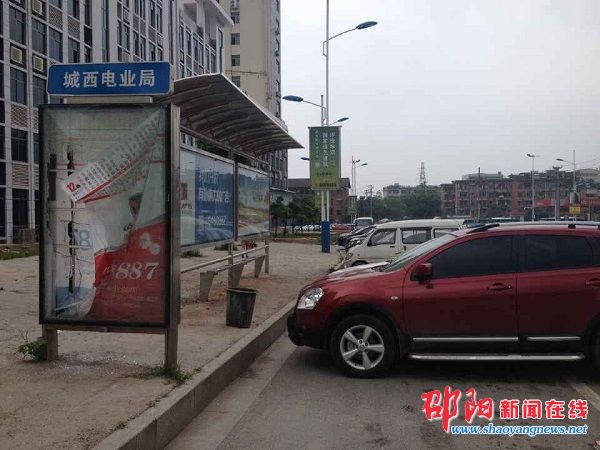 城西电业局公交站台前停满私家车 站牌被人恶意损坏