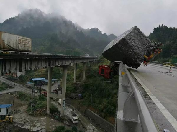 沪昆高速重型半挂牵引车冲破护栏悬挂空中情况危急