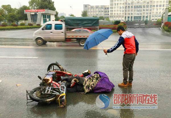 老人倒地不起 小伙雨中撑伞