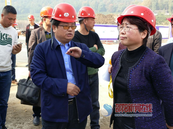周迎春（右一）听取新宁县委常委、常务副县长李荣卫（左二）介绍脱贫攻坚工作。