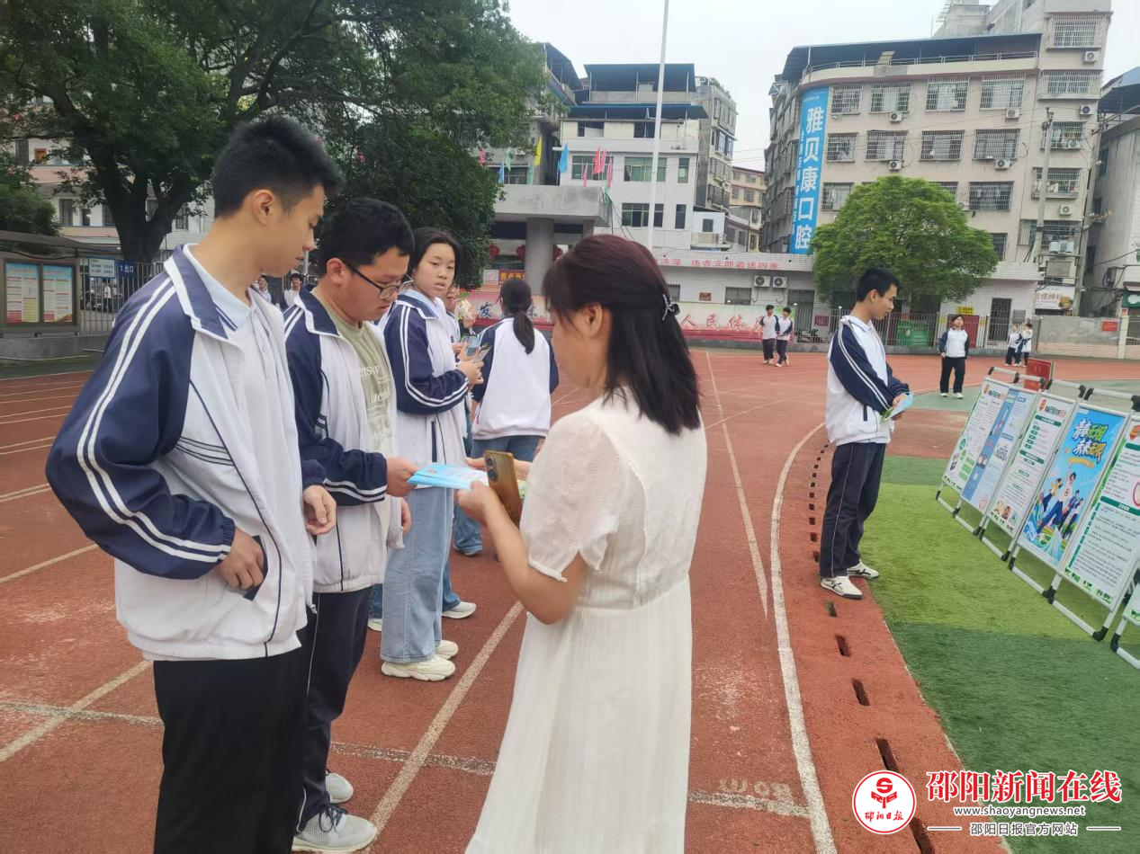 工作人员在对一中学子做宣传并发放宣传手册